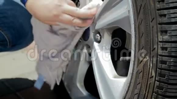 4k男司机用布清洁汽车轮辋的特写镜头视频的预览图