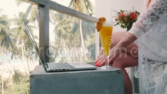 年轻女子在电脑上工作在热带地区放松视频的预览图