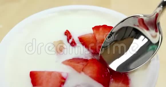 健康草莓和白色酸奶的特写男士用勺子吃饭健康食品的概念视频的预览图