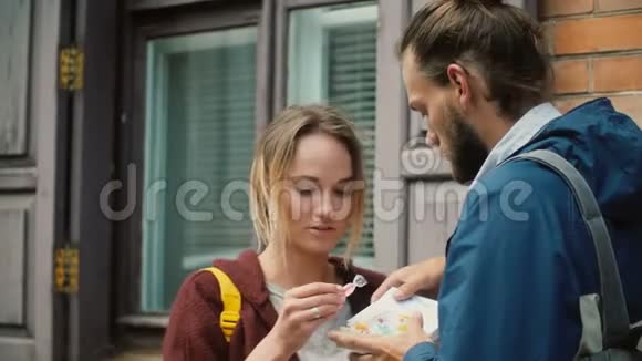 年轻快乐的男人和女人在外面用棋盘游戏打开盒子漂亮的一对夫妇把窒息装在里面信封视频的预览图