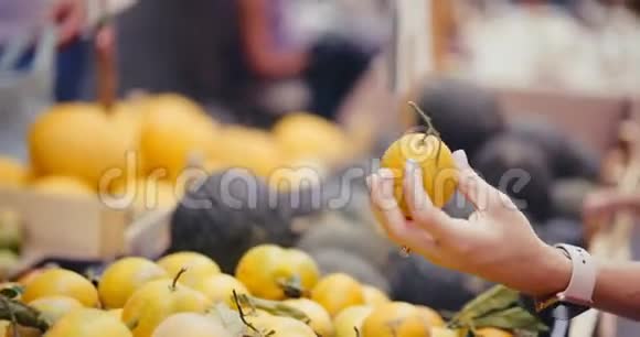 手在街头柜台挑选新鲜橘子视频的预览图