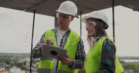 建筑工人男女戴头盔讨论房屋建筑方案相互转告视频的预览图