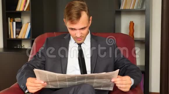 这位商人坐在椅子上看报纸他不快乐富有表现力4慢动作视频的预览图