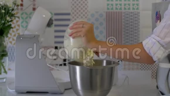 糕点厨师把奶油倒入搅拌机视频的预览图