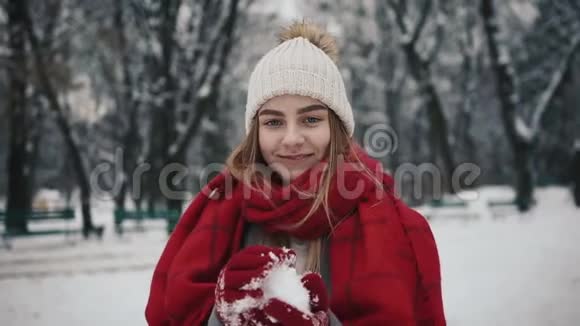年轻有活力的女人在镜头前扔雪球在冬天有乐趣的户外视频的预览图