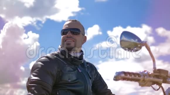 戴着太阳镜的摩托车手环顾四周微笑着视频的预览图
