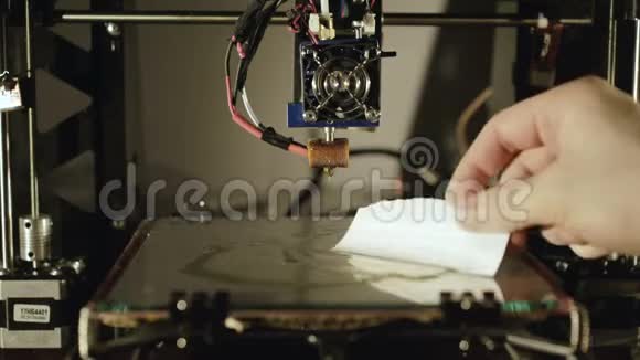 一个人在带有面筋的3D打印机中浇注玻璃表面4K视频的预览图
