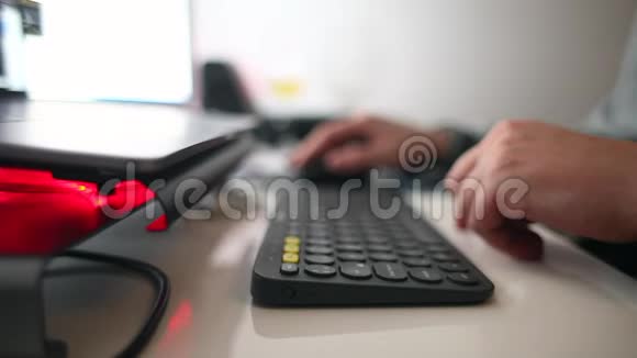 手在键盘上输入办公用品和笔记本电脑视频的预览图