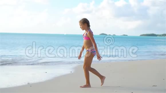 可爱的快乐小女孩走在白色的海滩上流动电视视频的预览图