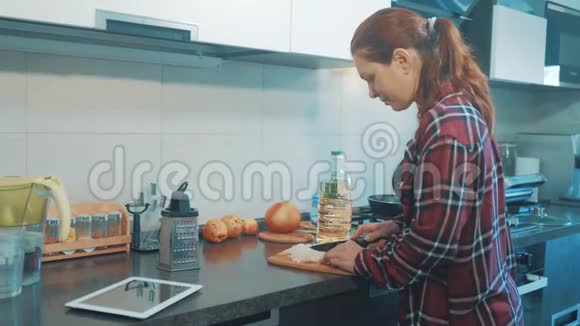 女人妈妈在厨房做饭的概念在平底锅里煮汤在木板上切洋葱女孩的母亲视频的预览图