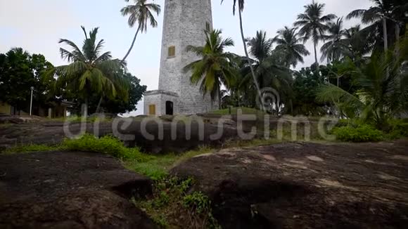 从一个美丽的灯塔的地面上拍摄它矗立在热带岛屿上的一座小山上视频的预览图