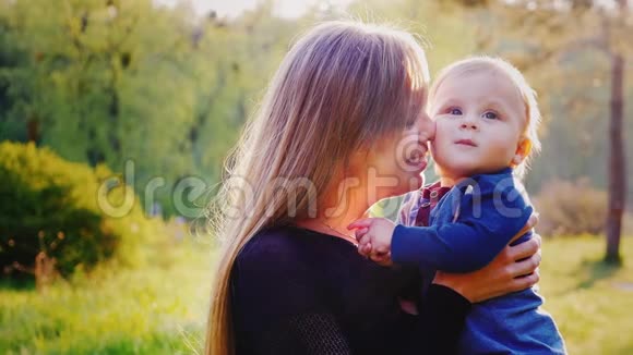 一个快乐的母亲和一个小男孩的肖像孩子在笑都很开心日落前美丽的灯光视频的预览图