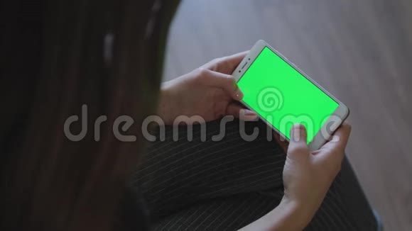兴奋的女孩在智能手机上玩电子游戏绿色屏幕视频的预览图