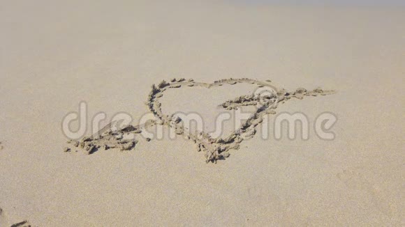 心的形状沙上的箭被海浪冲走视频的预览图