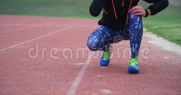 女运动员在跑道4k上系鞋带视频的预览图