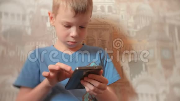 七岁的男孩认真地用手机浏览互联网视频的预览图