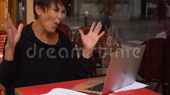 慢动作老年姐姐用笔记本电脑与亲戚交谈视频的预览图