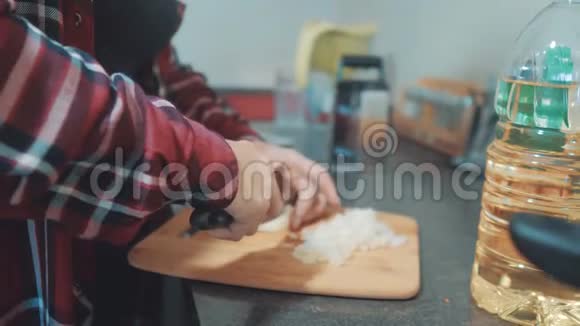 女人妈妈在厨房做饭的概念在平底锅里煮汤在木板上切洋葱女孩的母亲视频的预览图