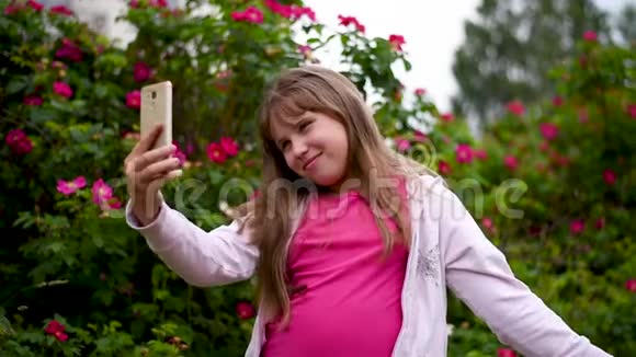 一个金发的欧洲女孩在智能手机上拍照视频的预览图