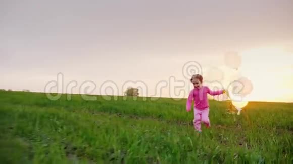有趣的女孩4年来在绿茵草地上用气球奔跑视频的预览图