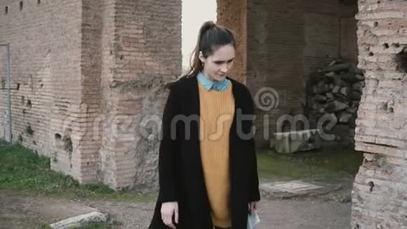 一位妇女正在意大利罗马一座古堡的院子里探险触摸古色古香的柱子的女孩视频的预览图