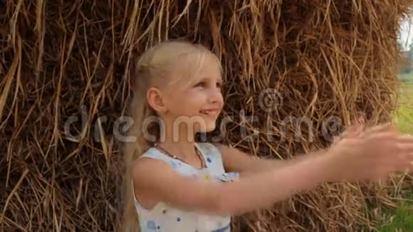可爱的金发女孩喝新鲜的牛牛奶从一个粘土罐对抗干草堆在农场夏天视频的预览图
