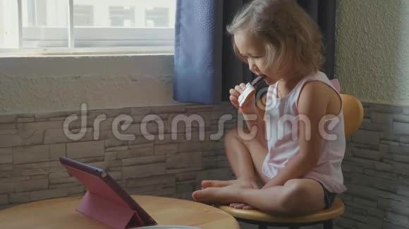小可爱的小女孩在平板电脑里看东西吃水果吧视频的预览图