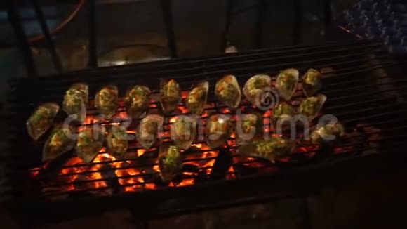 在亚洲夜市的一个烧烤场上烹制海鲜的过程视频的预览图
