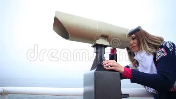 女人透过海岸的旅游望远镜度假胜地视频的预览图