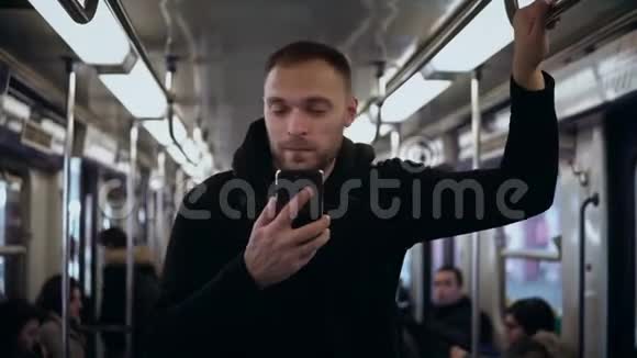年轻时尚的男人坐火车旅行使用带有触摸屏的智能手机男性在地铁上网视频的预览图