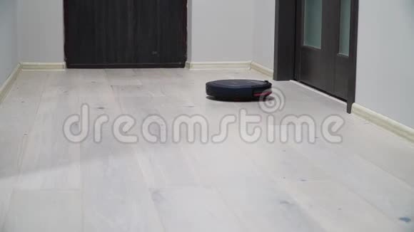 层压木板地板上的机器人吸尘器智能清洁技术吸尘器清洁公寓视频的预览图