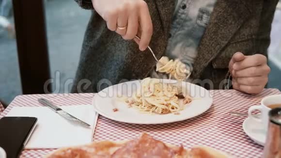 年轻的帅哥坐在咖啡馆的桌子旁享受着这顿饭饥饿的男性在餐馆吃美味的意大利面视频的预览图