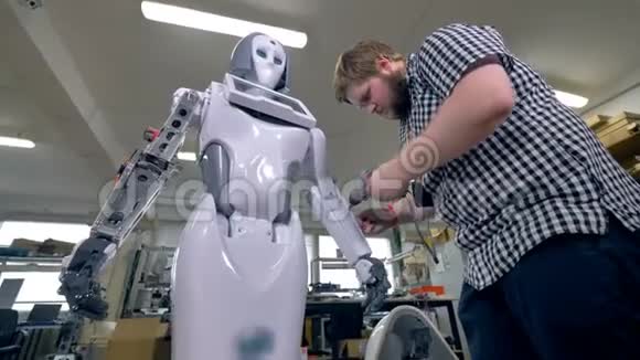 一位工程师在机器人前臂上使用便携式螺丝刀视频的预览图