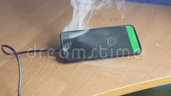 智能手机躺在桌子上吸烟和燃烧很快火就要开始了火灾危险概念视频的预览图