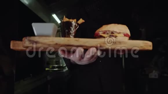 微笑的主厨穿着制服看着相机拿着盘子和美味的汉堡视频的预览图
