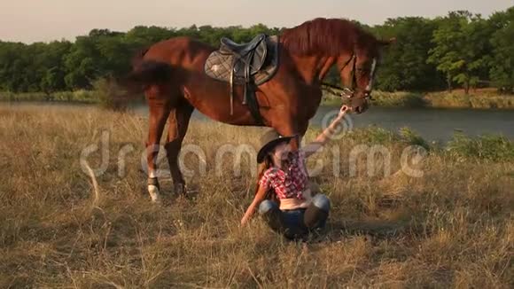 日落时女孩骑着马向摄像机摆姿势视频的预览图
