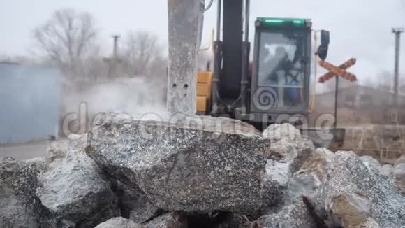 建筑工人坐在拖拉机的车轮后面用它可以把石头分成金属喷嘴视频的预览图