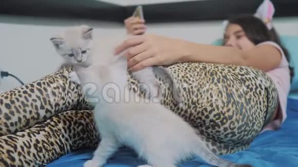 搞笑视频两只小猫在躺在床上的小女孩身上玩2两只小猫的爪子挨着一只视频的预览图