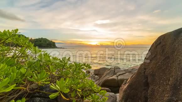 泰国普吉岛日落时分海滩上有热带植物的岩石视频的预览图