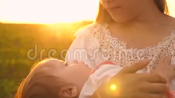 日落时分一个小婴儿睡在母亲的怀里慢镜头拍摄视频的预览图