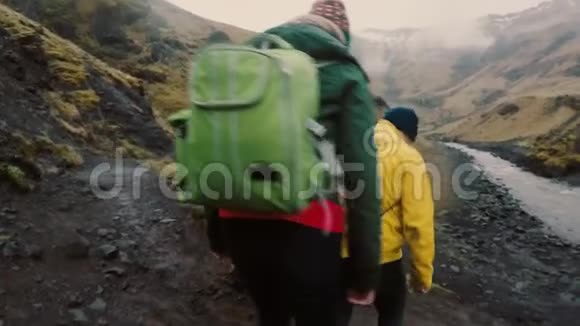 一群带背包的年轻人一起去野营朋友在河边的岩石上散步视频的预览图