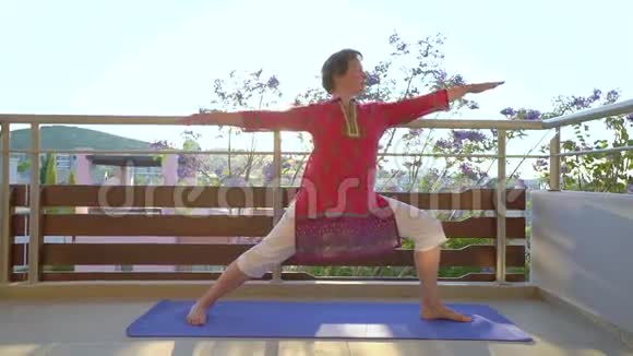 早上瑜伽在公寓露台上做瑜伽的女人视频的预览图