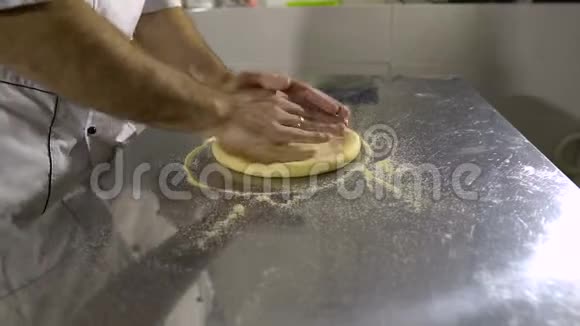在厨房做饭准备一个圆面包产品旋转和揉捏他的手视频的预览图