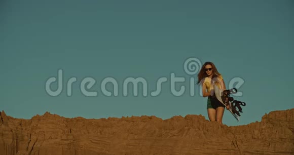 悬崖上的女孩沙艇运动员夕阳视频的预览图
