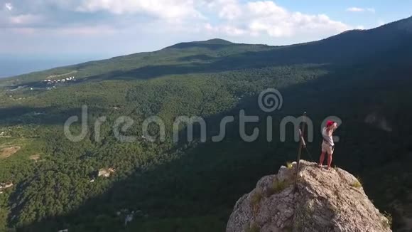 空中徒步旅行者摄影师手持相机站在山岩上令人惊叹的旅行冒险自然景观高清高清视频的预览图