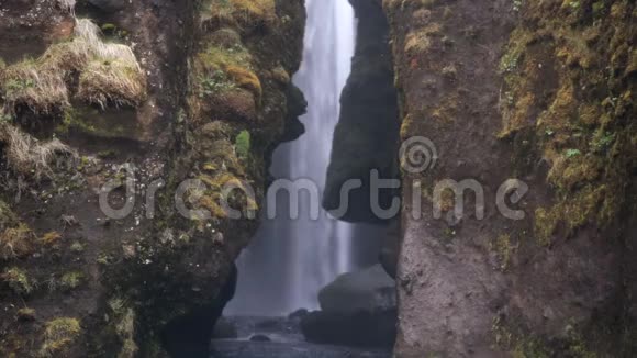 男人和女人穿着雨衣探索冰岛著名的风景在Gljufrabui瀑布的美丽景色视频的预览图