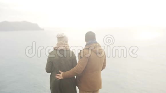 年轻漂亮的夫妇站在海边欣赏风景转身离去视频的预览图