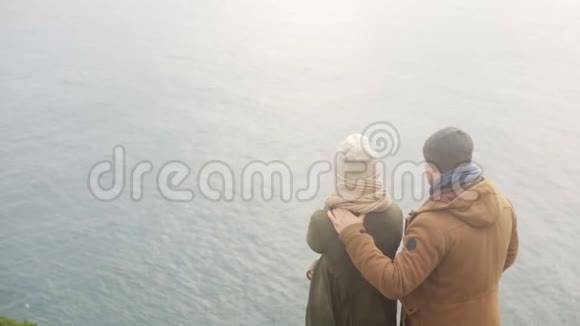 后景年轻时尚夫妇站在海边一起欣赏美丽的风景视频的预览图