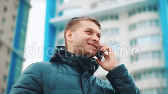 年轻的城市男子冬季商人专业的智能手机在街上行走使用应用程序短信信息关于视频的预览图