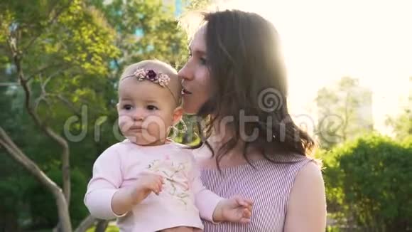 小女婴漂亮妈妈拥抱户外慢动作视频的预览图